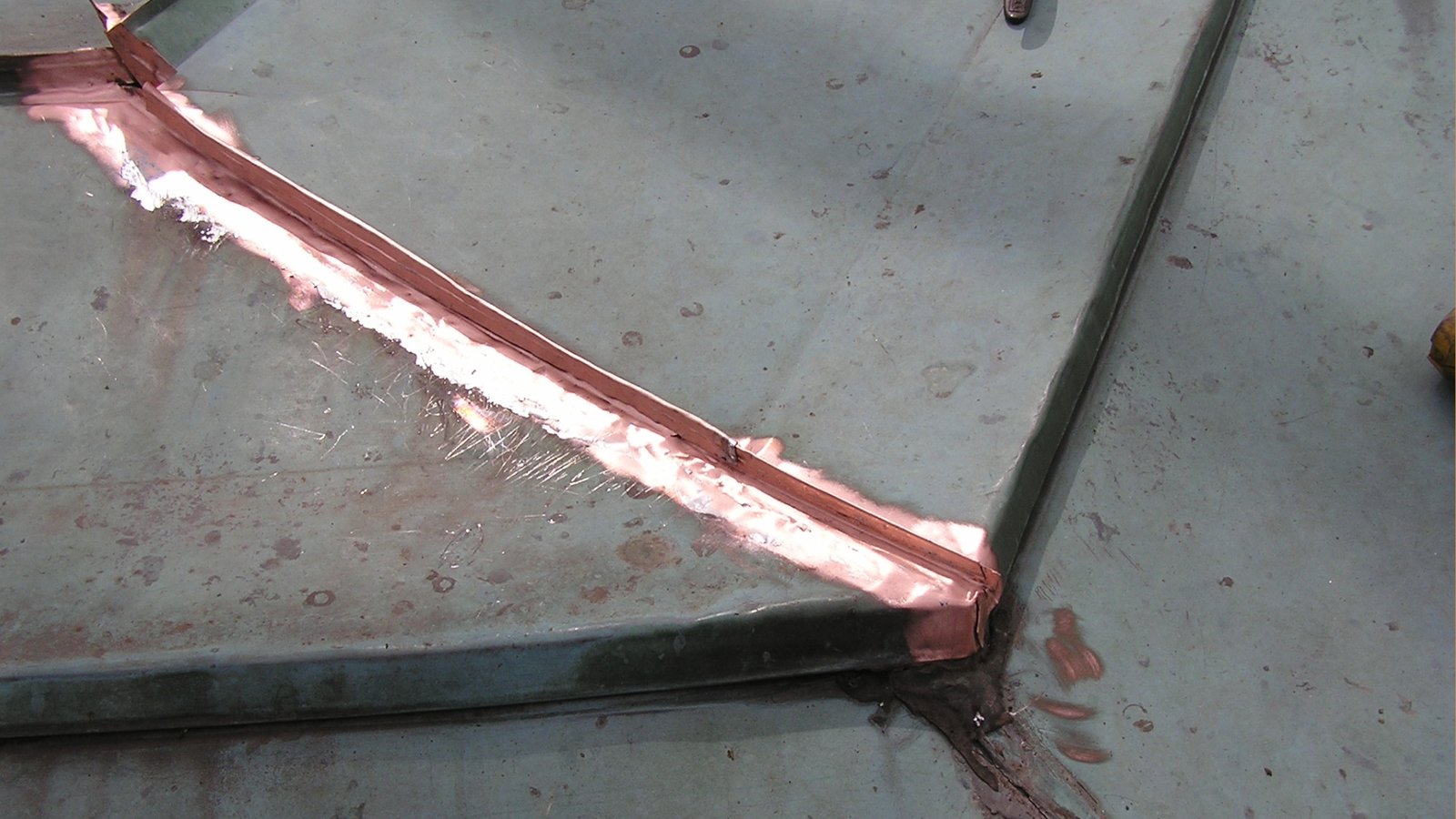 Copper flat seam cleaned to shiny surface for soldering 